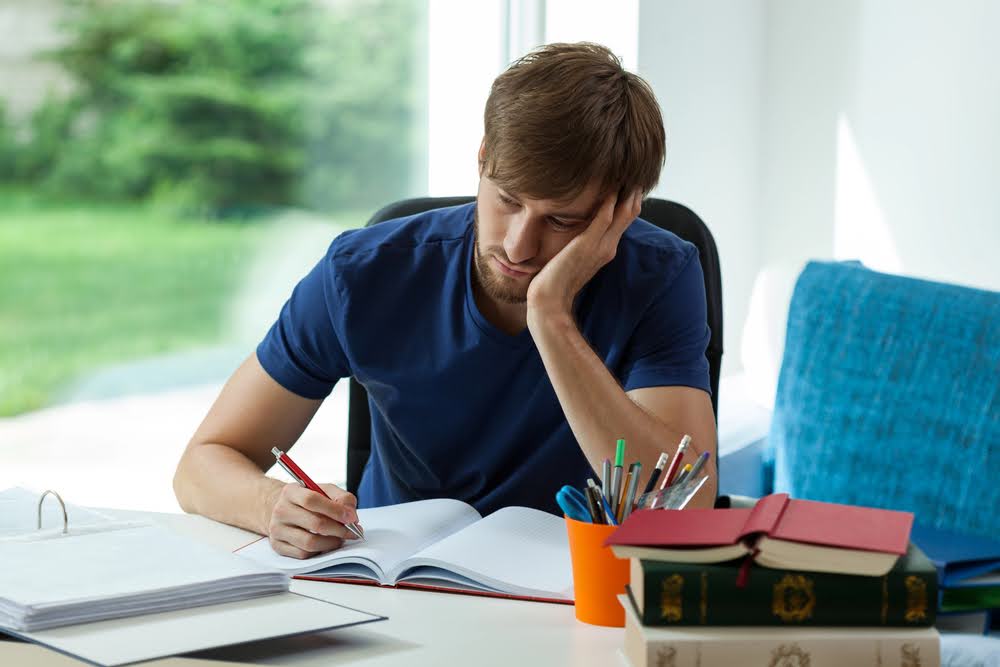 Person writing in a notebook symbolizing mental health treatment in Columbus and London, OH