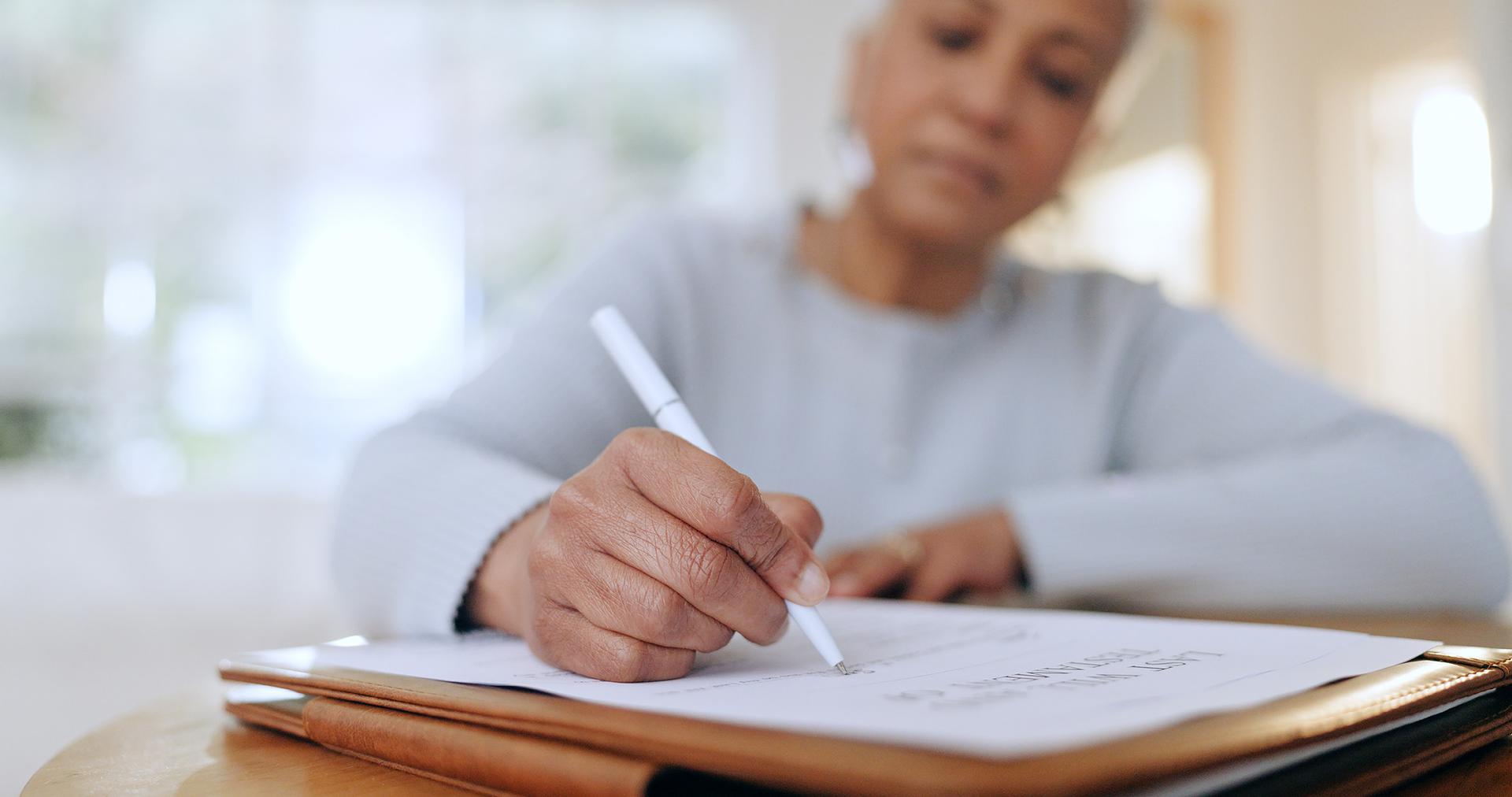 An Elderly Woman Is Completing Insurance Paperwork for Addiction Recovery Treatment in Columbus, OH